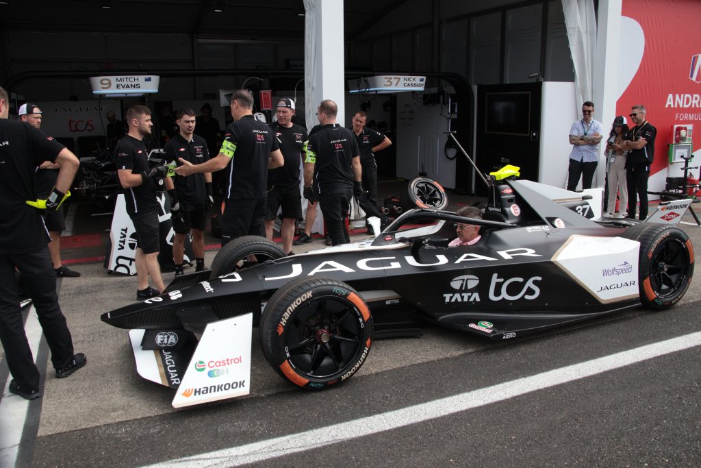 Members of the operational crew of Formula E teams wear numbered yellow arm bands and garages have closed circuit cameras to manage the number of people working on the vehicles